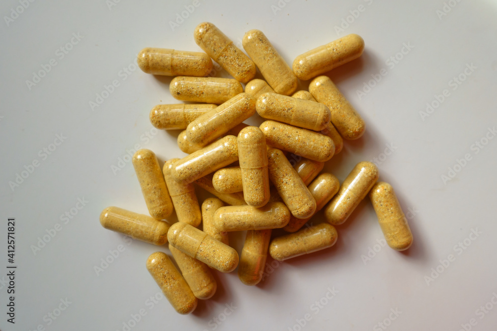 Fistful of orange cellulose capsules of multivitamins from above Fistful of orange cellulose capsules of multivitamins from above