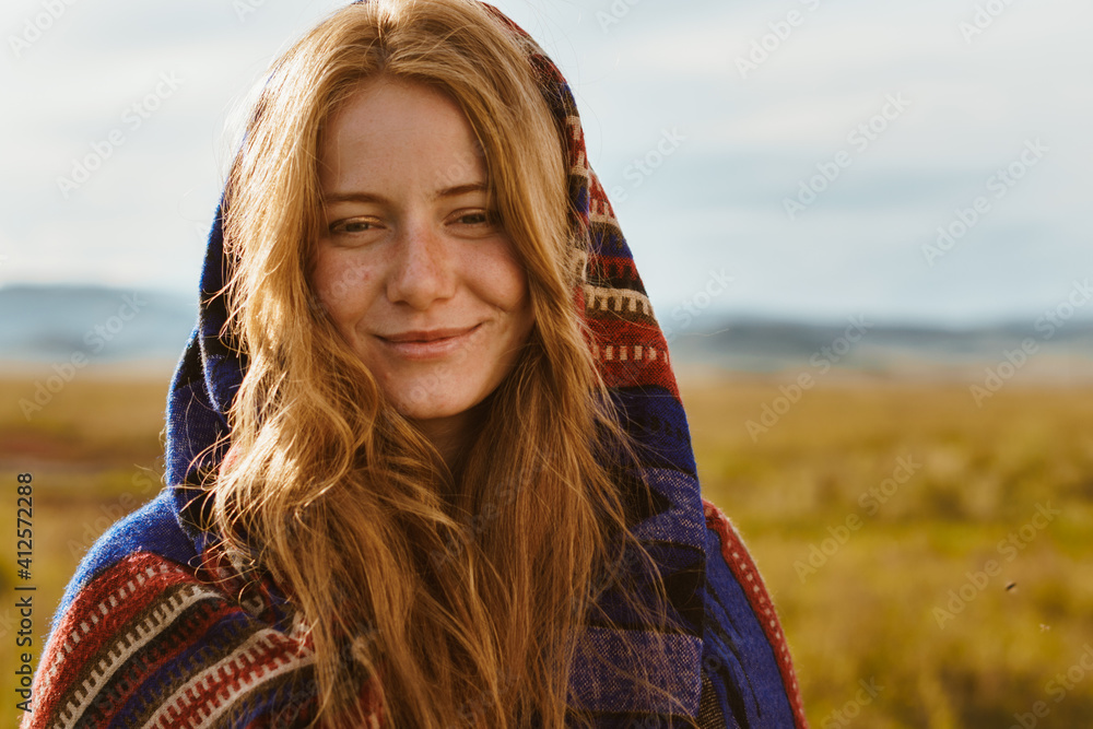 close-up. a girl with a natural beauty red-haired in an ethno cape smiles against the desert steppe. High quality photo close-up. a girl with a natural beauty red-haired in an ethno cape smiles against the desert steppe. High quality photo