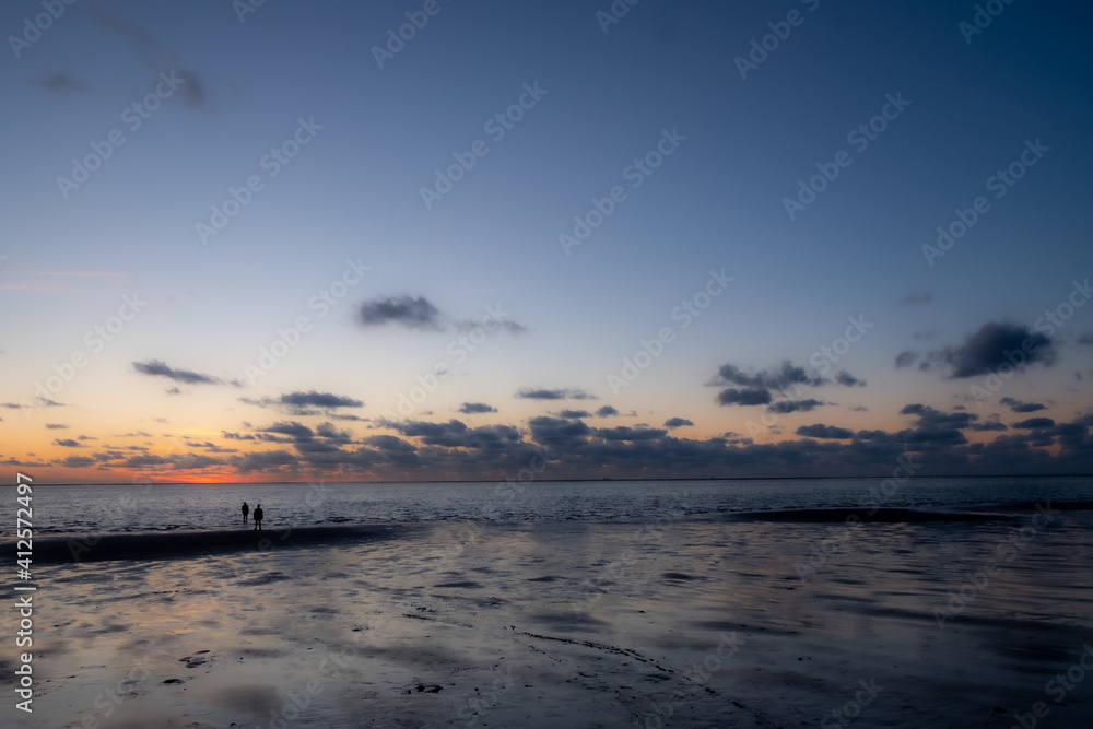 View of the setting sun shining on the Sea and reflected on the beach, clouds with sun-shining edges. Landscape. High quality photo showing concept of freedom and dreams