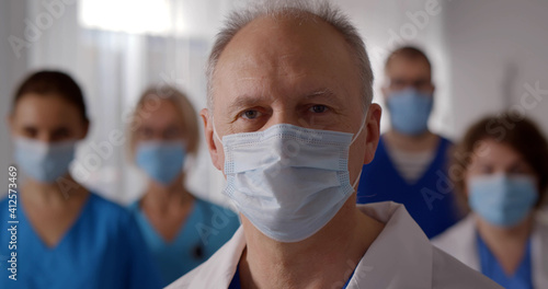 Team of professional male and female doctors wearing protective mask in hospital