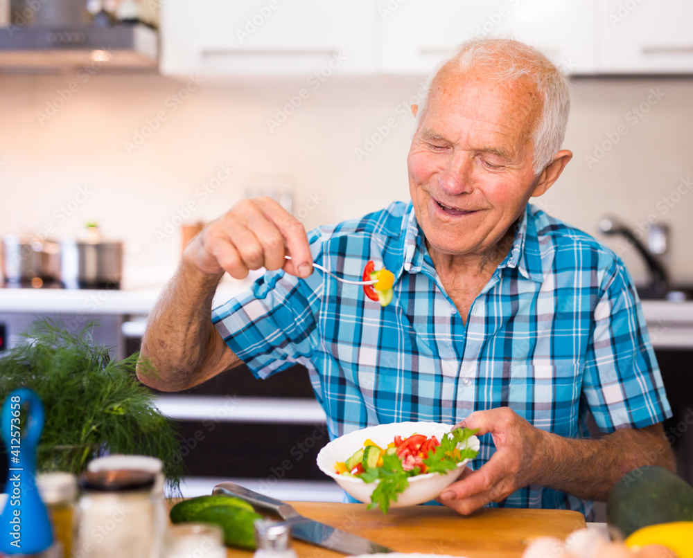 elderly man eating fresh vegetable salad at home elderly man eating fresh vegetable salad at home