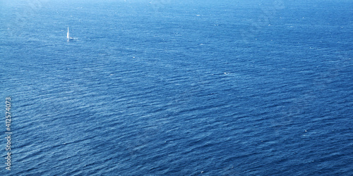 Blue sea surface with waves and boat