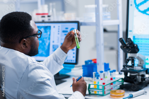 Professional African-American scientist is working on a vaccine in a modern scientific research laboratory. Genetic engineer workplace. Future technology and science.
