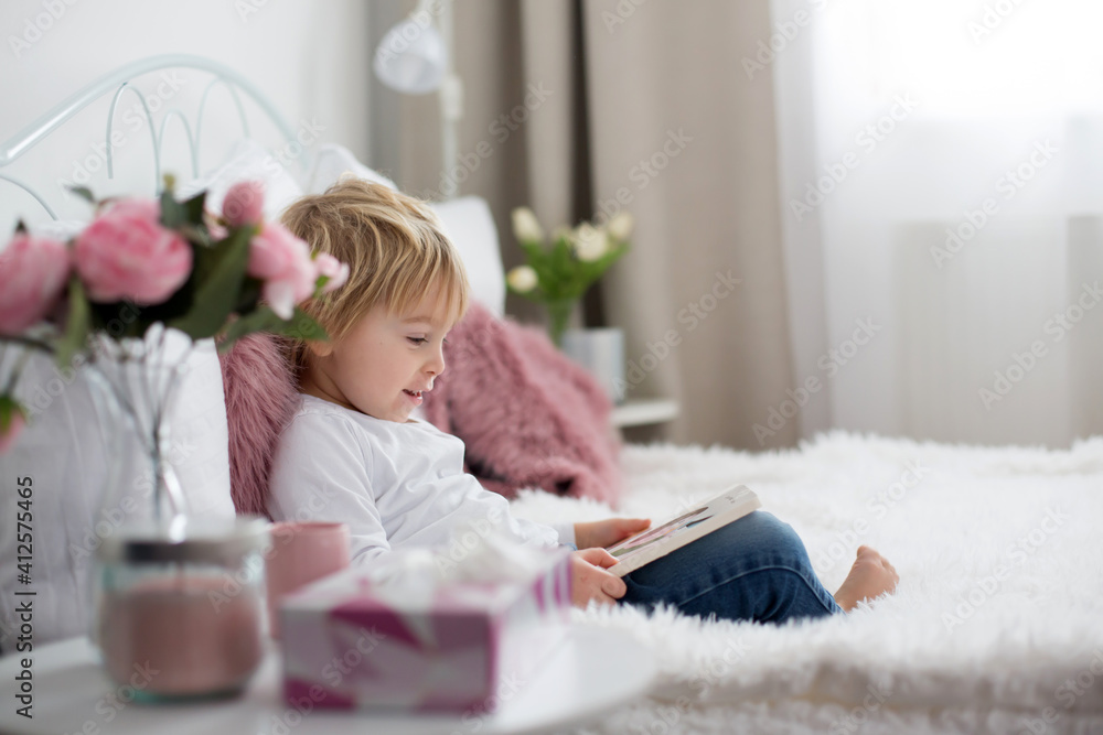 Cute child, lying in bed, reading book Cute child, lying in bed, reading book