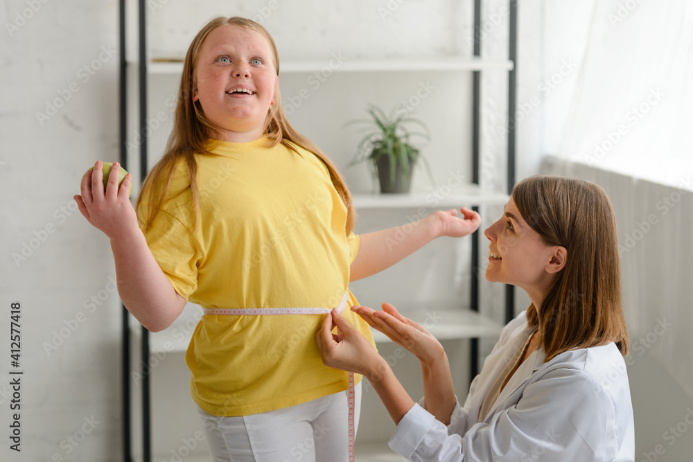 Girl's waist being measured by a nutritionist Girl's waist being measured by a nutritionist