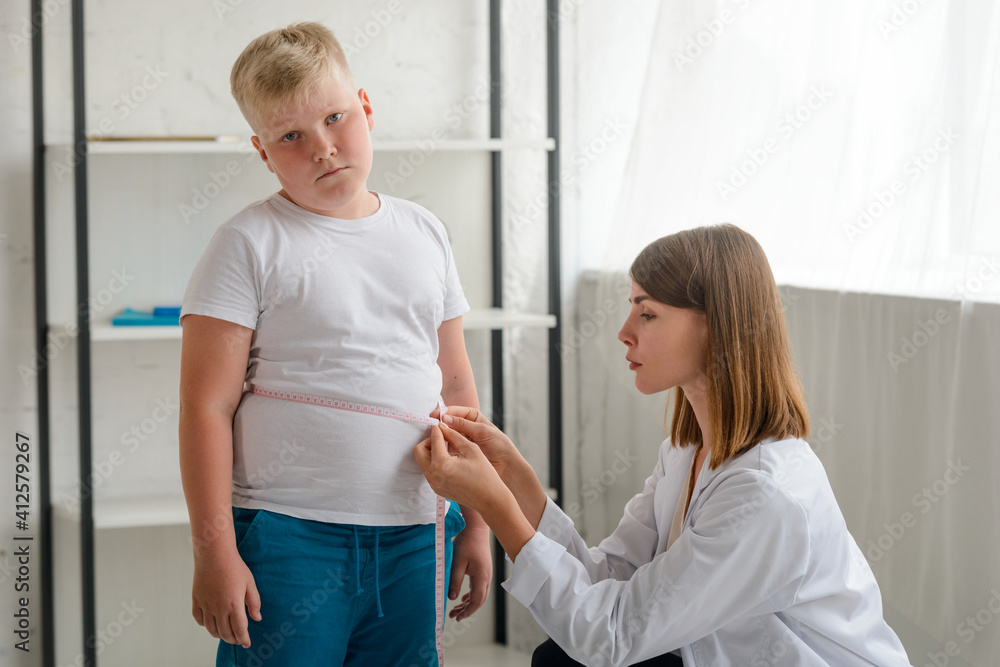 Upset boy during waistline measurement at a nutritionist's appointment Upset boy during waistline measurement at a nutritionist's appointment