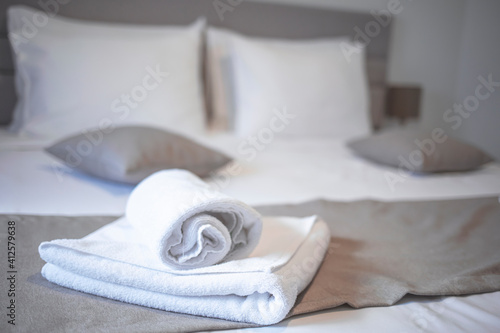 Clean towels on bed at hotel room. Bed maid-up with clean white pillows and bed sheets in beauty bedroom. Close-up. interior background. Towel in Hotel Room , Welcome guests , Room service
