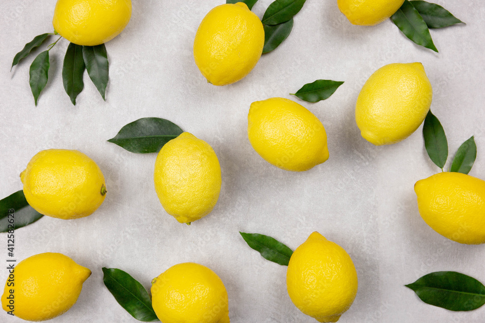 Fresh lemons with leaves on white concrete stone background. Vitamin C concept, immune defence.Top view. Fresh lemons with leaves on white concrete stone background. Vitamin C concept, immune defence.Top view.
