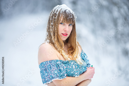 close up portrait of beautiful smiling confident young woman pretty face in bikini looking at camera and posing alone at snowy forest photo