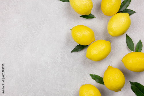 Fresh lemons with leaves on white concrete stone background. Vitamin C concept, immune defence.Top view. Copy space.