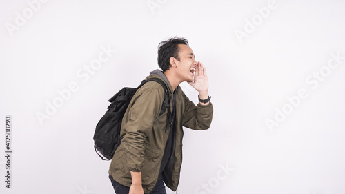 Young student man wearing a bag shouting and yelling isolated on white backgroud