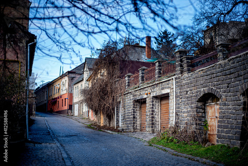 staninny town street, mystical cityscape, old paving stone in a European city, facades of stone houses