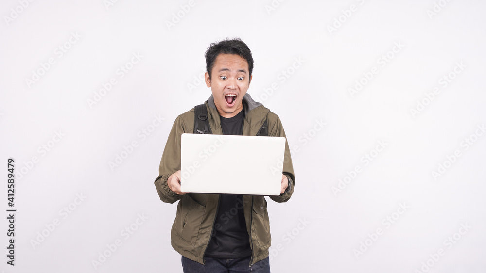 The young man wearing bag shouting and yelling on a white background with laptop The young man wearing bag shouting and yelling on a white background with laptop