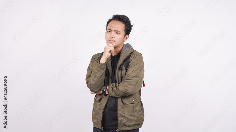 The young man wearing a bag on a white background was thinking The young man wearing a bag on a white background was thinking