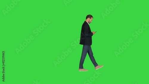 Businessman using smartphone while walking by on a Green Screen, Chroma Key.