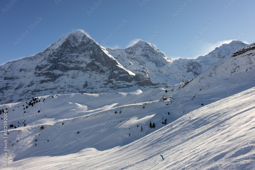 Obraz premium View of the Swiss mountains in winter. Eiger in clouds, Monoch and Jungfrau. Swiss alps in Switzerland Jungfrauregion.
