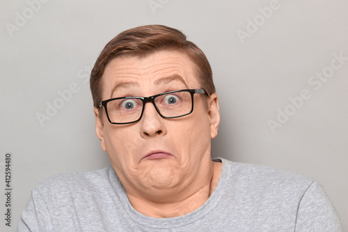 Portrait of confused surprised mature man with glasses