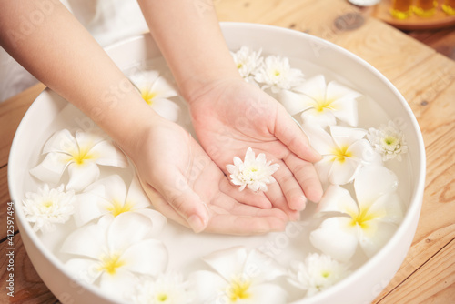 Spa treatment and product for female feet and hand spa. white flowers in ceramic bowl with water for aroma therapy at spa.