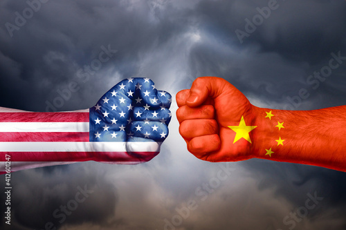 Flags of USA and China painted on two fists on sky background Fototapeta