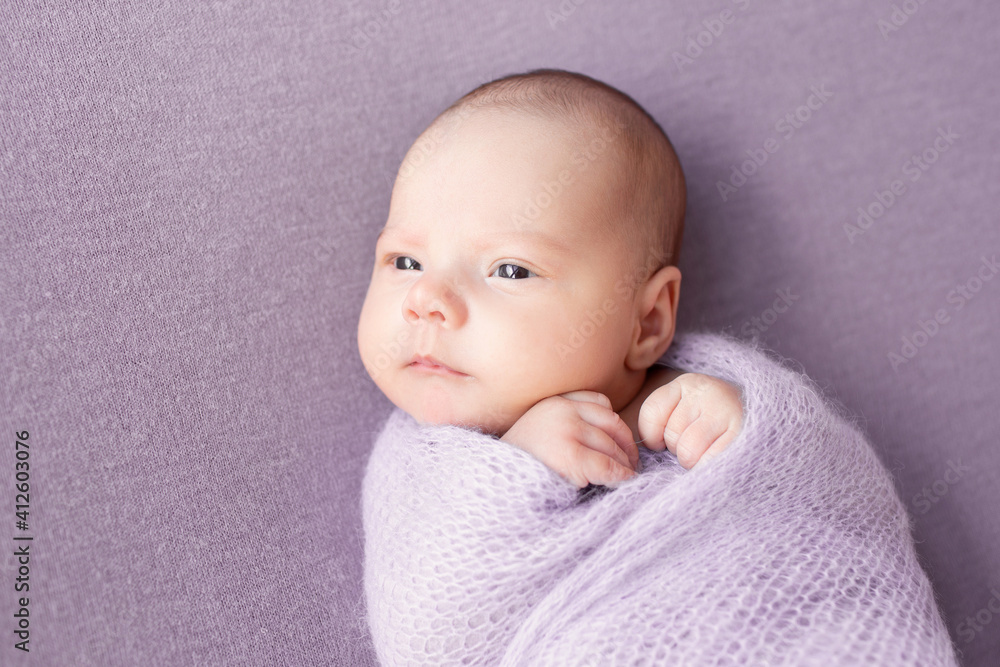 Newborn baby girl on a lilac background. Sweet newborn baby. The first photo session of the baby. Newborn baby girl on a lilac background. Sweet newborn baby. The first photo session of the baby.