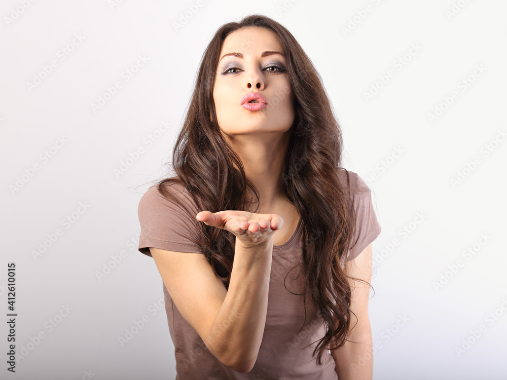 Beautiful business woman send the kissing sign and blow it from the