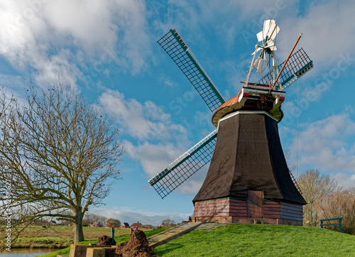 Traditional windmill by a river, Wynhamsterkolk, Rheiderland, East Frisia, Lower Saxony, Germany photo
