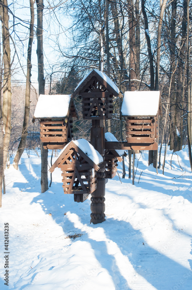 Several large wooden bird feeders on a pole. Winter panorama. Several large wooden bird feeders on a pole. Winter panorama.