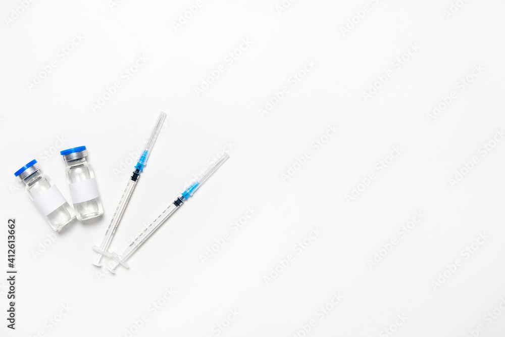 Flat lay of syringes and bottles for influenza vaccine on the white background. The concept of injection for prevention and health care. Vaccination. Top view, lay out, copy space, ampoule mockup. Flat lay of syringes and bottles for influenza vaccine on the white background. The concept of injection for prevention and health care. Vaccination. Top view, lay out, copy space, ampoule mockup.