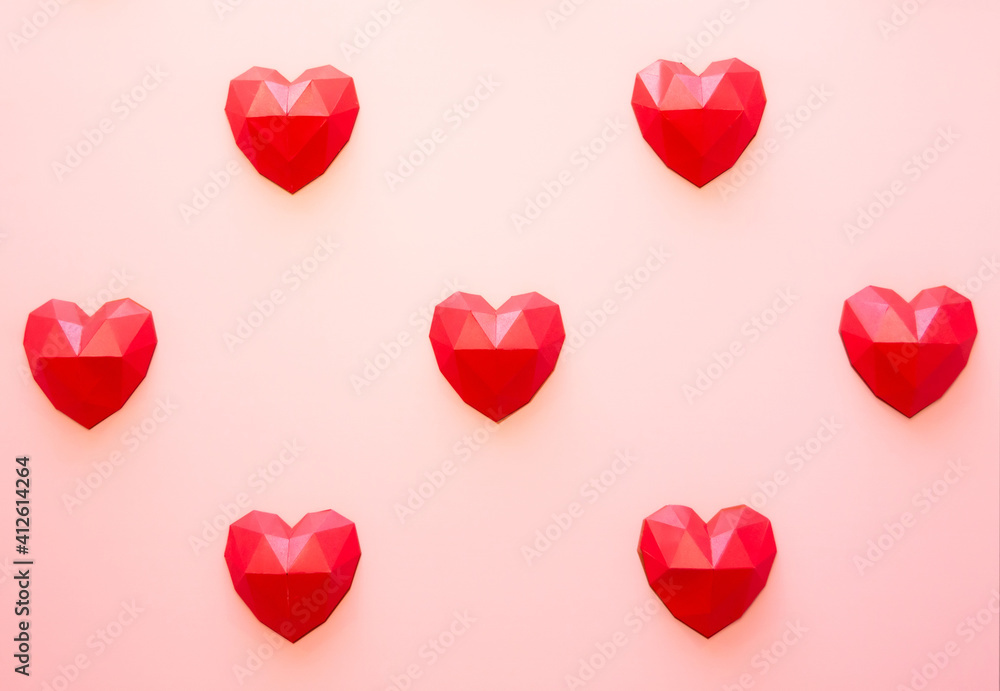 Holiday background for Valentine's Day, Red polygonal paper heart shapes on a cream background. Love concept. Plain. Minimalistic style.