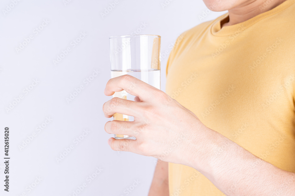 Man holding glass of water isolated grey background. Clean drinking water in clear glass. Man holding glass of water isolated grey background. Clean drinking water in clear glass.
