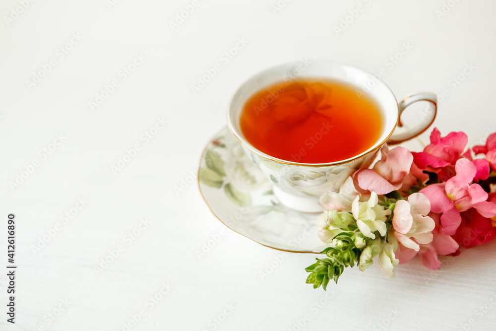Porcelain cup of herbal tea and flowers on light background. Selective focus, soft focus. copy space Porcelain cup of herbal tea and flowers on light background. Selective focus, soft focus. copy space