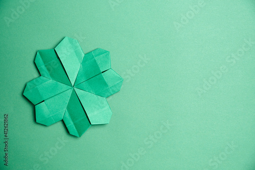 St. Patrick's Day card: four-leaf paper clover on green background