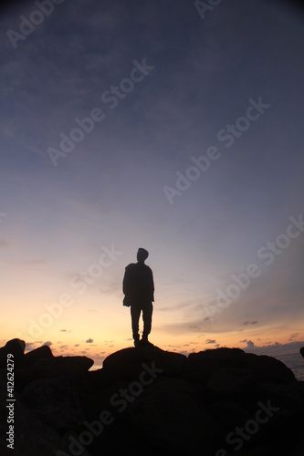silhouette of a man standing on top of the mountain