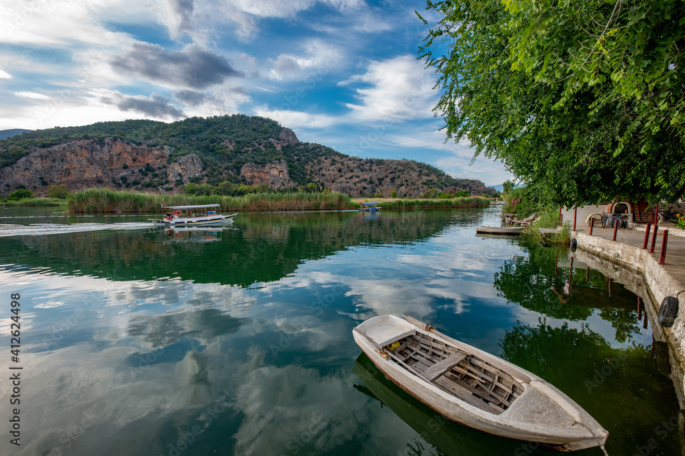 Fototapeta premium June13, 2020. Dalyan, Mugla - Turkey. Boats view at slope of Lycians rock tombs in Dalyan Town.