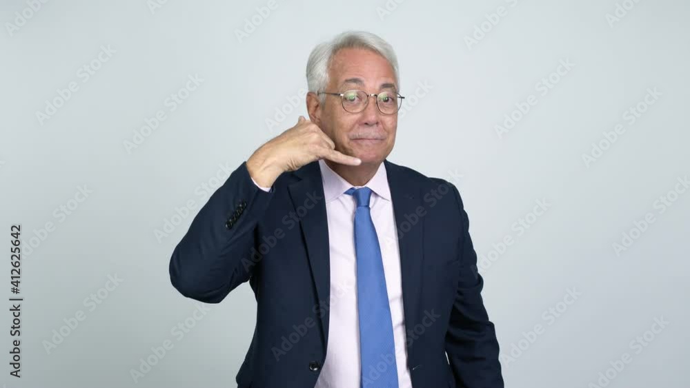 Middle age businessman making phone gesture and speaking with someone. Call me back sign over isolated background Middle age businessman making phone gesture and speaking with someone. Call me back sign over isolated background