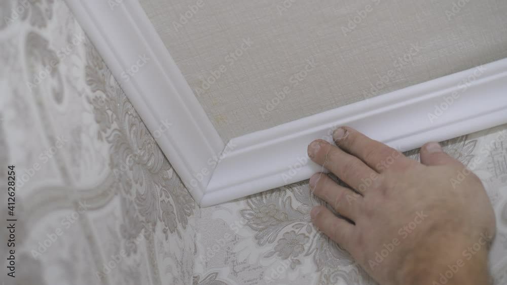 Installation of a ceiling skirting board on liquid nails to a ceiling, a wall. Installation of a ceiling skirting board on liquid nails to a ceiling, a wall.