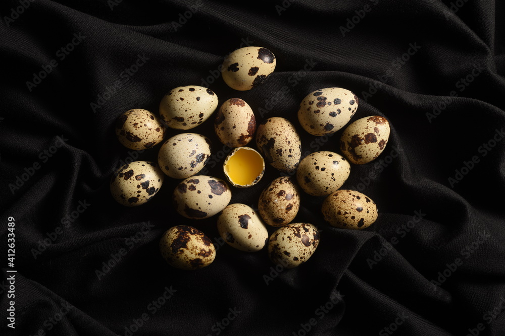 Quail eggs on a piece of black cloth. Close-up shot. Quail eggs on a piece of black cloth. Close-up shot.