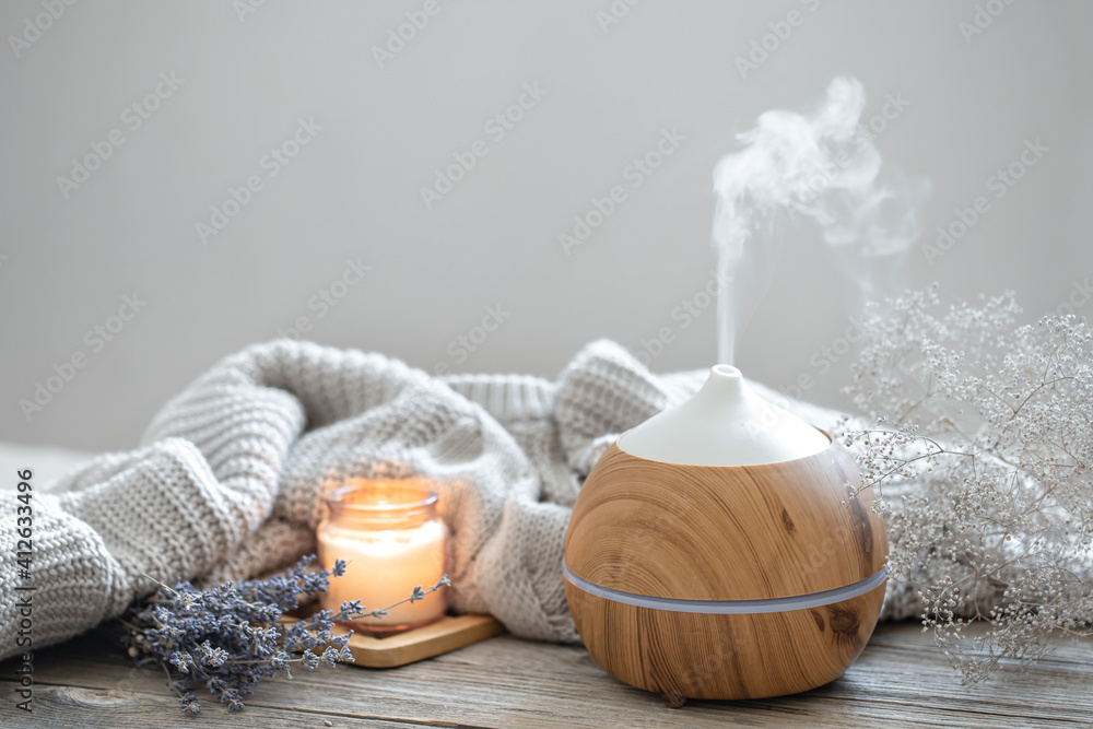 Cozy home composition with air humidifier, knitted element, lavender and candle copy space. - obrazy, fototapety, plakaty 