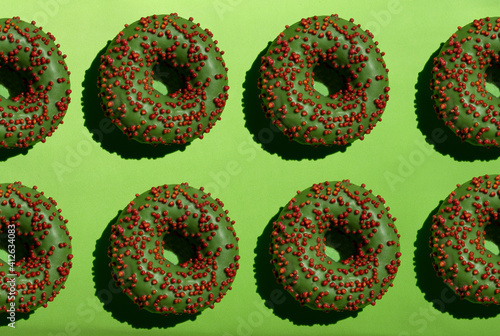 Green donuts with red crumb on a green background