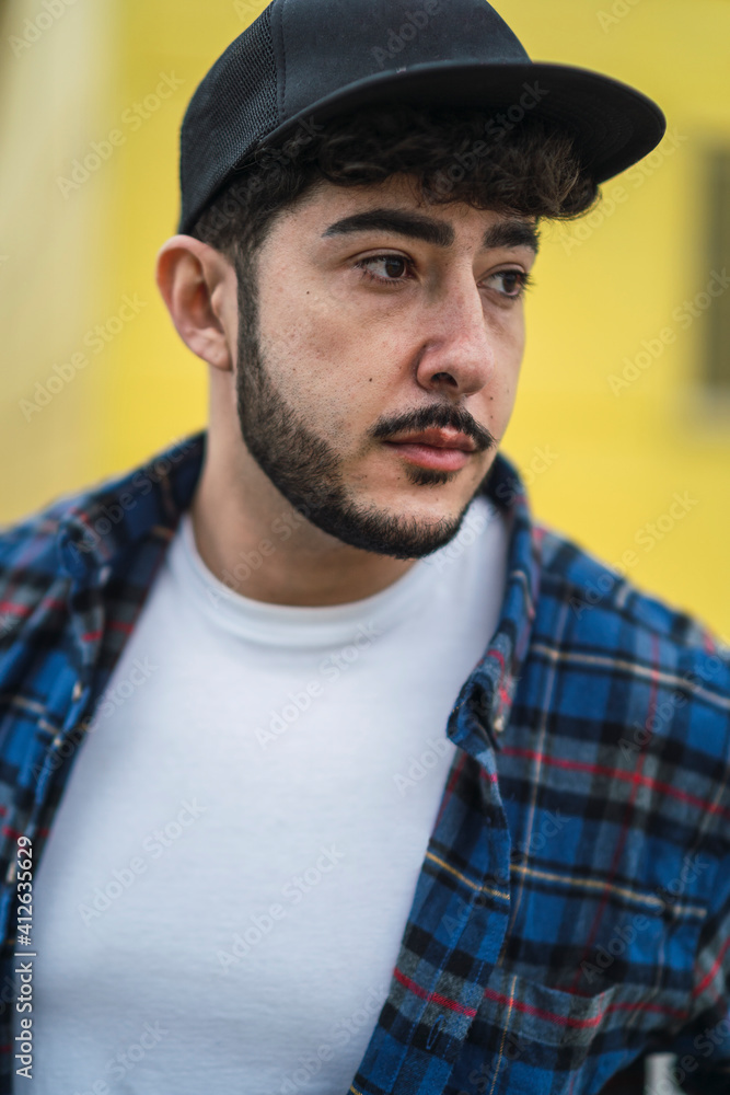 Chico atractivo joven con barba con ropa casual y camisa con skate Chico atractivo joven con barba con ropa casual y camisa con skate