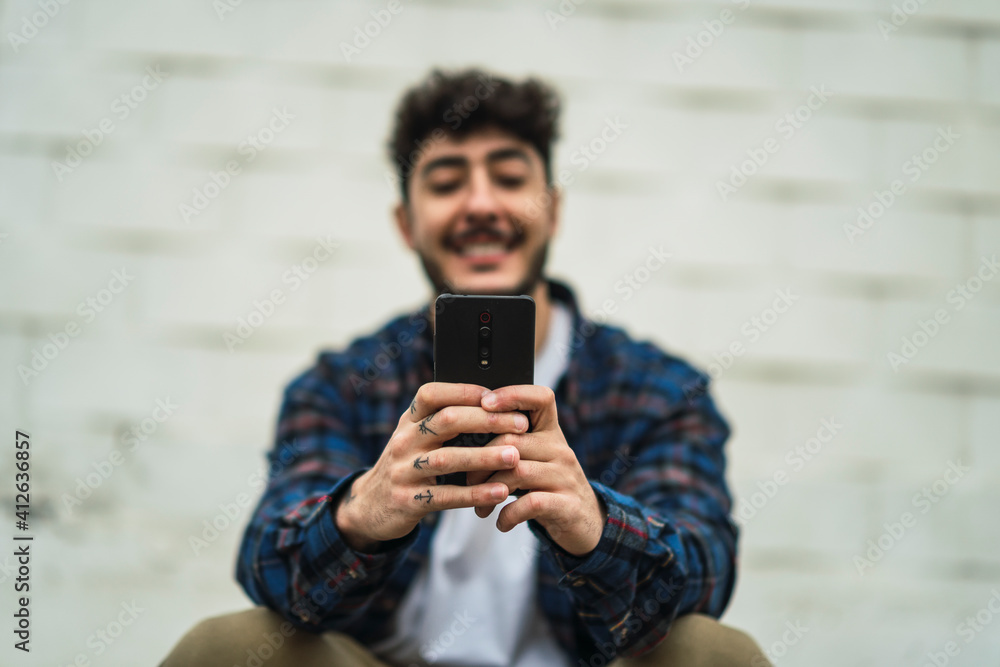 Fototapeta premium Chico atractivo joven con barba con ropa casual y camisa con skate