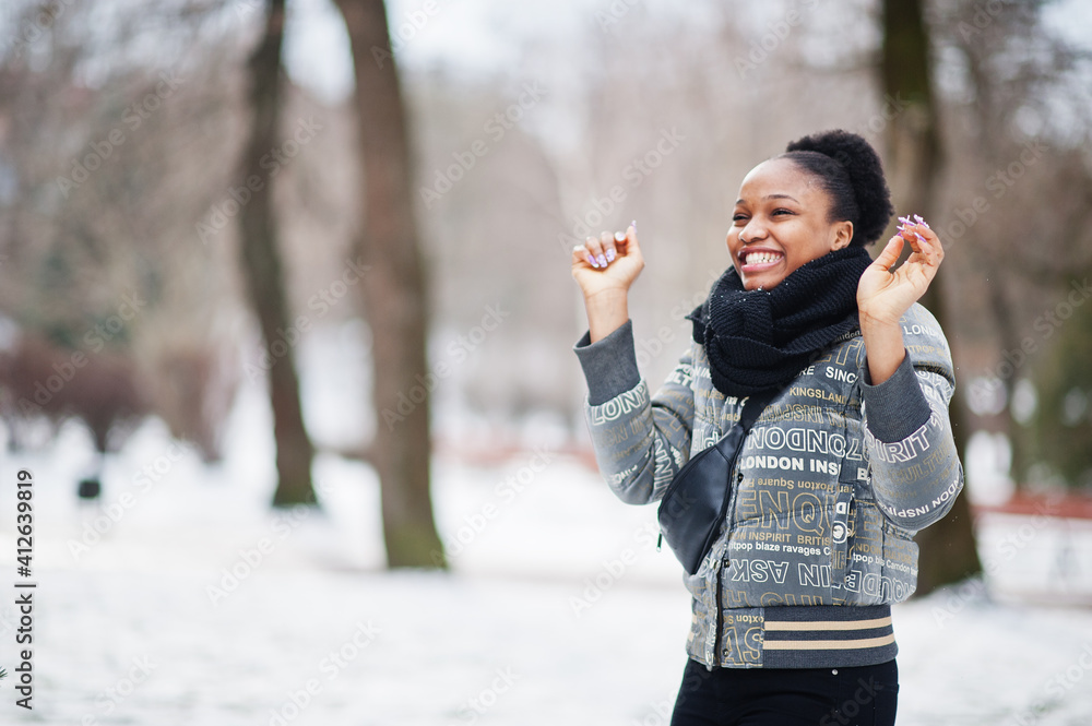 African woman wear in black scarf pose in winter day at Europe throw snow in the air. African woman wear in black scarf pose in winter day at Europe throw snow in the air.