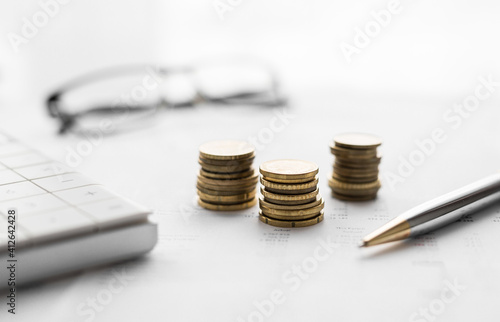 Close up of a calculator and coins on a financial data background