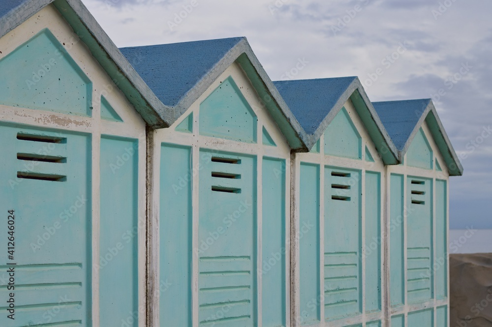 Blue beach sheds on the sand in a winter day (Pesaro, Italy, Europe)