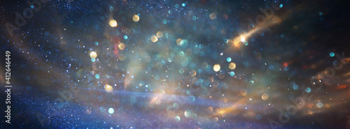 background of abstract blue, gold and black glitter lights. defocused