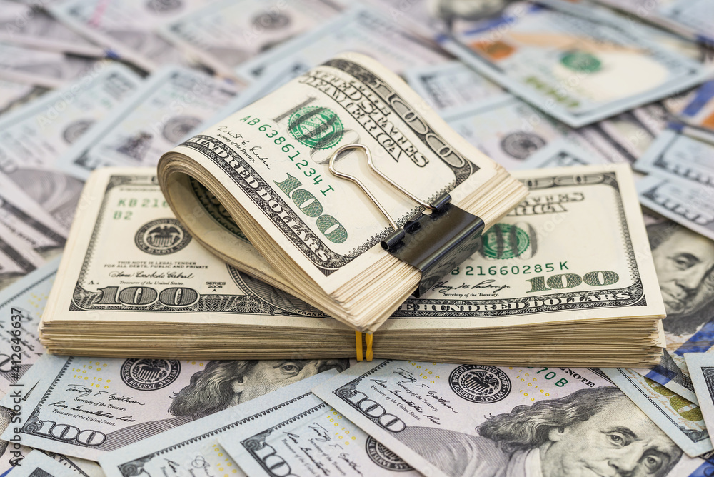 Stack of dollars and dollars with a metal clip on the money background. Stack of dollars and dollars with a metal clip on the money background.