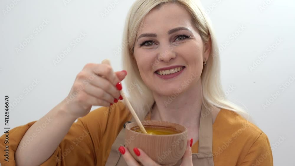 smiling young woman with bowl of honey on white background smiling young woman with bowl of honey on white background