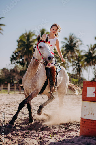 Fotografie little girl running barrels on horse back