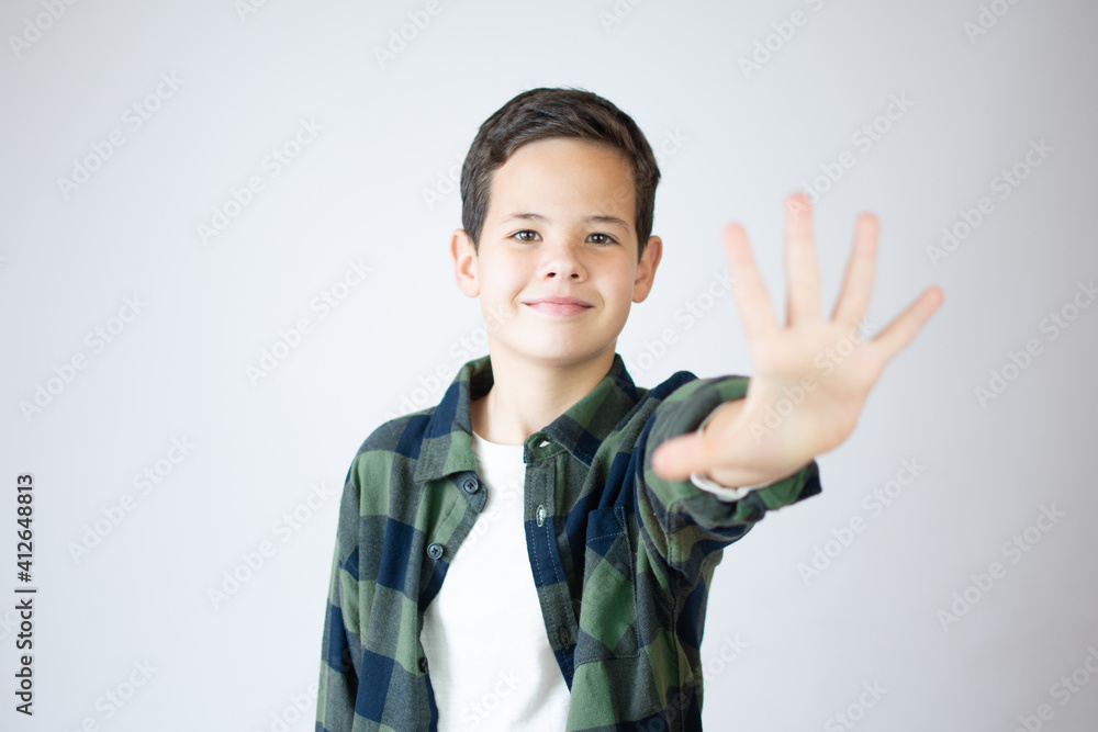 Young caucasian little boy standing against white wall showing and pointing up with fingers number five while smiling confident and happy. Young caucasian little boy standing against white wall showing and pointing up with fingers number five while smiling confident and happy.