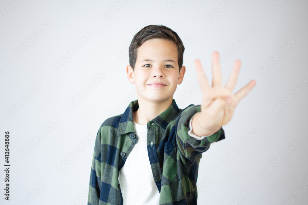 Young caucasian little boy standing against white wall showing and pointing up with fingers number four while smiling confident and happy. Young caucasian little boy standing against white wall showing and pointing up with fingers number four while smiling confident and happy.